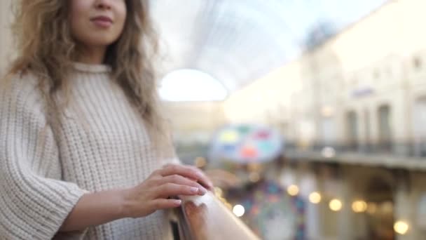 Mujer joven caminando por el centro comercial sonriendo. Cliente femenino en pasillo de centro comercial en busca de ventas. Concepto de consumismo de compras — Vídeos de Stock