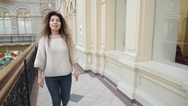 Mulher de compras andando e sorrindo no shopping. Menina bonita no centro comercial . — Vídeo de Stock