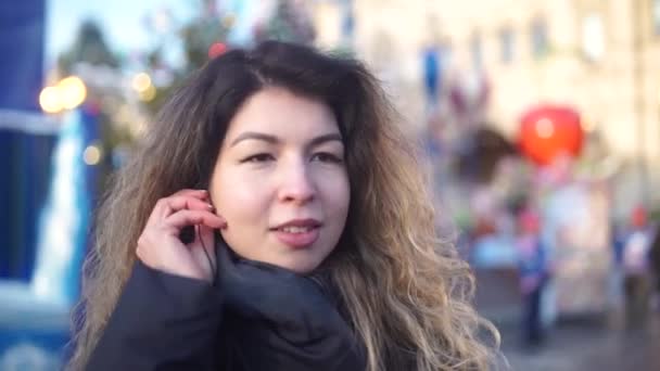 Mujer joven se encuentra en una cama y utiliza el teléfono inteligente, chica escucha la música a través de auriculares . — Vídeos de Stock