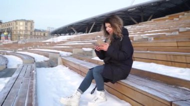 Mutlu genç kadın ASMS açık havada haliyle iyi haber heyecan ile gülümseyen cep telefonu üzerinde okuma