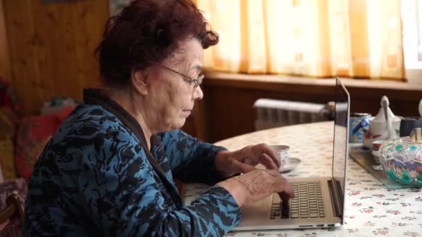 Zamyšlený starší žena myslí a pracují na notebooku — Stock video