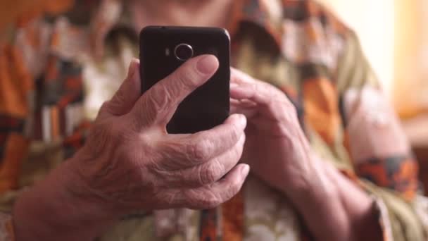 Ηλικιωμένη γυναίκα χρησιμοποιώντας νέο smartphone. Τα χέρια, κοντινό πλάνο — Αρχείο Βίντεο