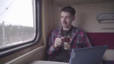 Genç adam oynamak ve zaman tablete geçen tren metroyla seyahat. Genç bir adam onun tablet metro tren commuting kullanarak HD klip.