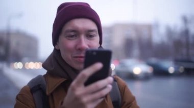 Portre. Telefonunu sörf mutlu bir genç adam portresi. Arka plan bulanık.