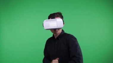 Sanal gerçeklik gözlüklü adam. Dijital video oyunu dünya gözlemleyerek bir sanal gerçeklik maskeli adam. VR. yeşil ekran.