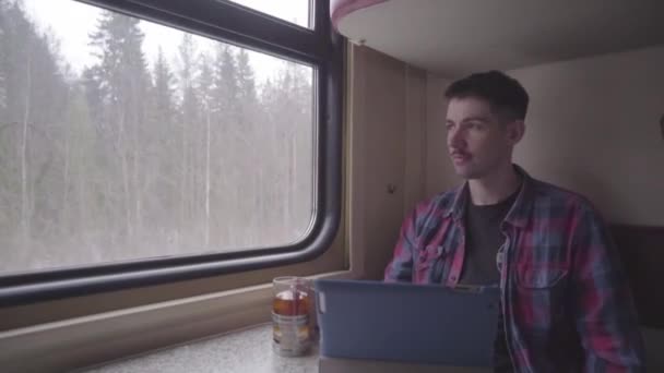 Jovem viajando de trem metrô jogando e passando o tempo em tablet.HD clipe de um jovem usando seu tablet enquanto viaja no trem de metro . — Vídeo de Stock