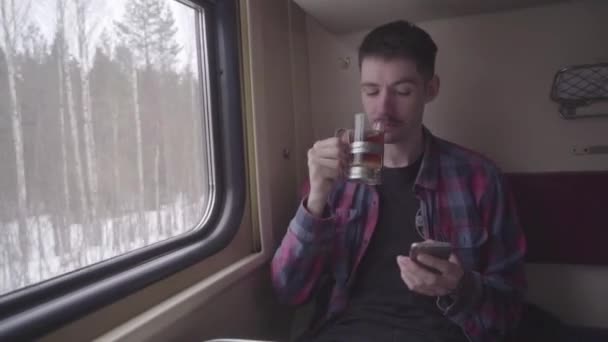 Ung vacker man med smartphone med pekskärm i tunnelbanan. Snygga hane i metro chatta med vänner. — Stockvideo