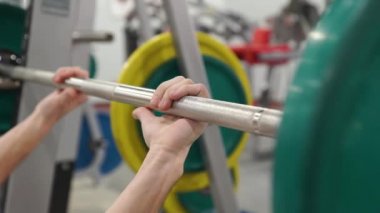 Grip - barbell bench press. Adam kulpları bar barbell bench press için. Makro. Yandan odaklan. Bench press halter portre yapan adam