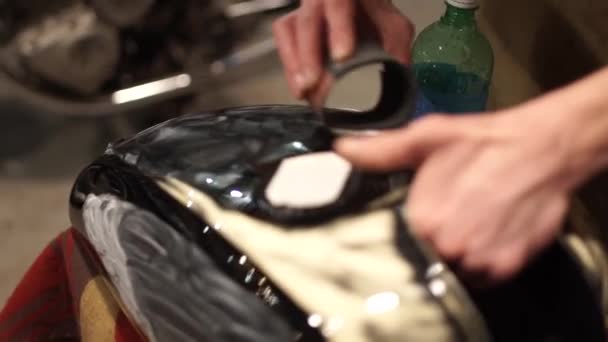 Ο τύπος στίλβωση μετάλλου-αερίου βυτίο με γυαλόχαρτο. Auto μηχανικός συναρμολογεί προσαρμοσμένη μοτοσικλέτα στο εργαστήριό του. Τύπος δημιουργούν μια αποκλειστική ΜΗΧΑΝΩΝ café racer στο γκαράζ. — Αρχείο Βίντεο