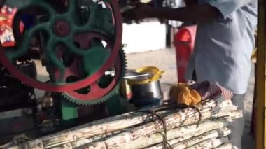 Onun suyu yapım süreci gösteren bir şeker kamışı suyu satıcı.