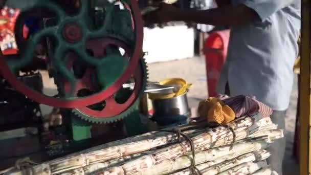 Um vendedor de caldo de cana de açúcar mostrando seu processo de fabricação de caldo . — Vídeo de Stock