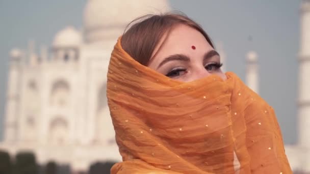 Mooie vrouw in traditionele Sari tegenover de Taj Mahal. achtergrond, Agra, Uttar Pradesh, India — Stockvideo