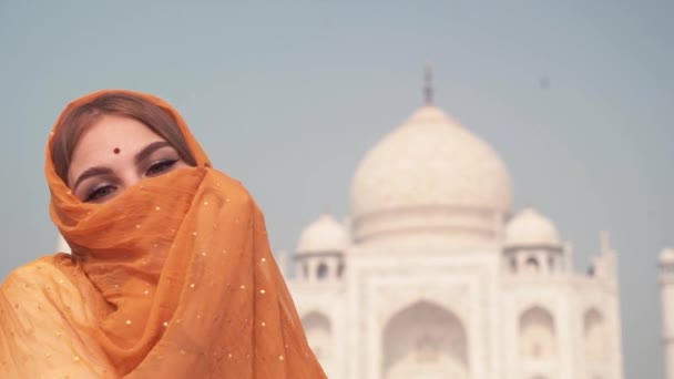 ताजमहल के सामने पारंपरिक साड़ी में सुंदर महिला। पृष्ठभूमि, आगरा, उत्तर प्रदेश, भारत — स्टॉक वीडियो