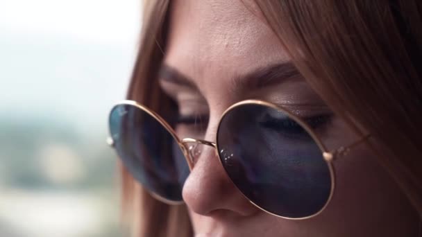 Close-up of redhead woman with green eyes and freckles looking at view in summer — Stock Video