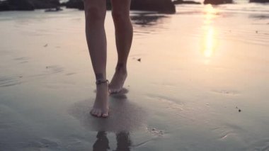 Güzel seksi kız sahilde bir mayo ile tatto günbatımında dans