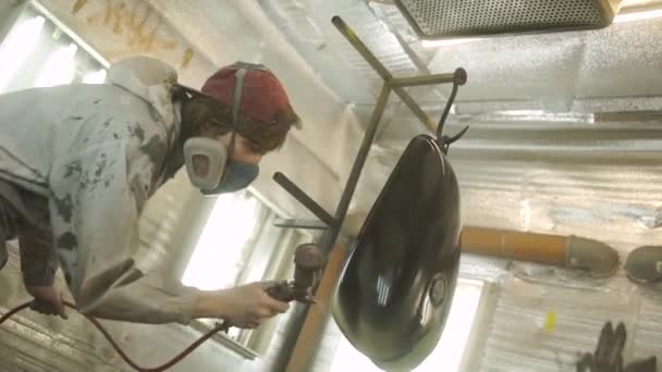 Filmagem de um tanque de gás de moto sendo pintado em uma câmara de pintura — Vídeo de Stock