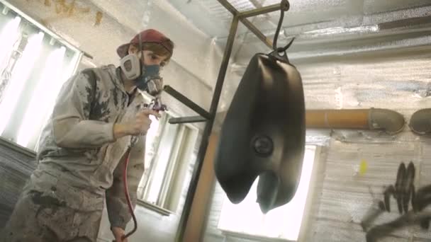 Filmagem de um tanque de gás de moto sendo pintado em uma câmara de pintura — Vídeo de Stock