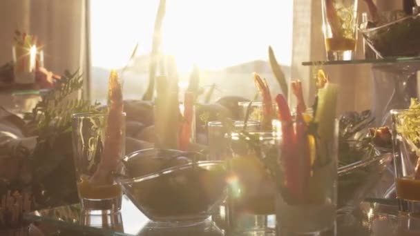 Table de banquet traiteur joliment décorée avec différentes collations et amuse-gueule au soleil lors de l'événement de fête d'anniversaire de Noël d'entreprise ou de la célébration de mariage . — Video