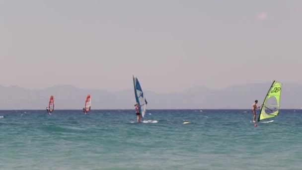 Grecce. Rhodos. 2018 Windsurfer atrapa rápidamente el viento y aumenta la velocidad en aguas de la bahía de Galway. Con otros windsurfistas — Vídeos de Stock