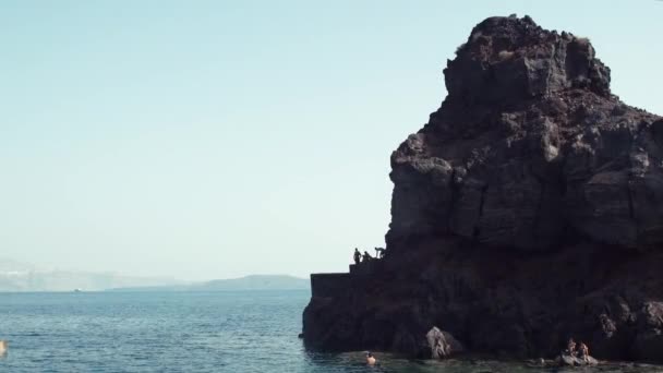 Un hombre saltando desde el acantilado hacia el océano. Estilo de vida divertido verano . — Vídeo de stock