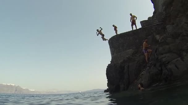 Санторіні. Греція. 2018 людина зістрибнути з скелі в океан. Літній спосіб життя. — стокове відео