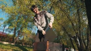 Genç adam bahçede barbekü hazırlıyor.