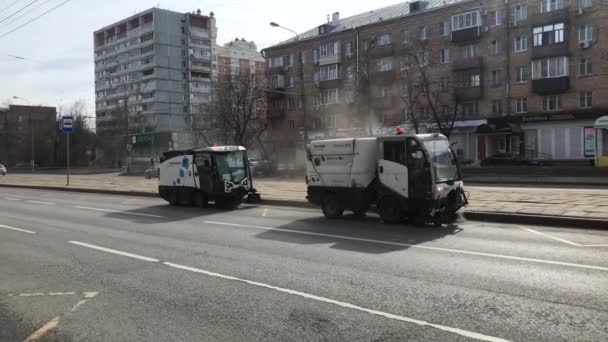 莫斯科。俄罗斯。2019. 街道清扫工用水清洗人行道和道路，用旋转刷子清洁. — 图库视频影像