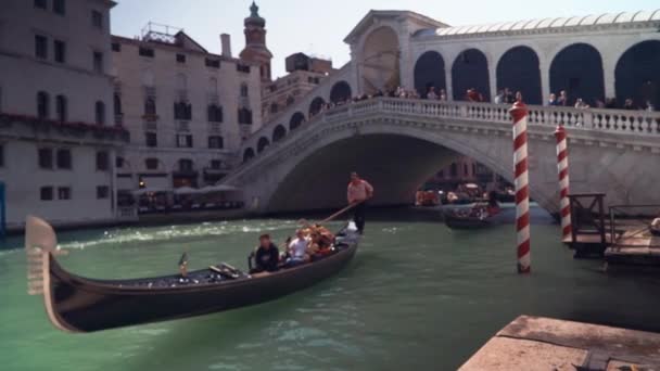 VENECIA, ITALIA, abril 2019: Góndolas con turistas nadan a lo largo de un canal en Venice Street, Italia. Canal de agua de Venecia. Edificios de arquitectura . — Vídeo de stock