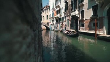 Venedik, İtalya, 2019: Turistlerle gondol, İtalya'nın Venedik Caddesi'nde dar bir kanal boyunca yüzüyor. Venedik Su Kanalı. Mimari binalar. Venedik'in dar sokakları insanların