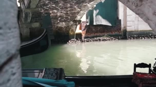 VENEZIA, ITALIA, 2019: Gondole con turisti nuotano lungo uno stretto canale in Venice Street, Italia. Canale delle Acque di Venezia. Edifici di architettura. Le stradine di Venezia su cui la gente — Video Stock