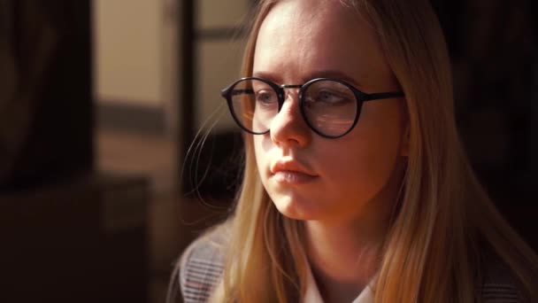 Lindo retrato de mujer caucásica en gafas con pelo largo y claro que de pie sobre fondo negro — Vídeo de stock