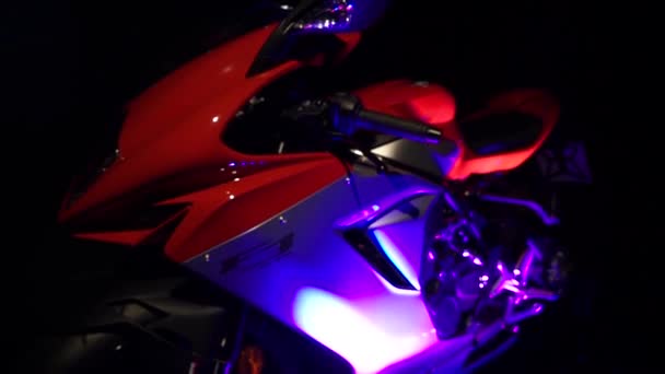 Nahaufnahme in Zeitlupe. Details des Motorrads bei Neonlicht — Stockvideo