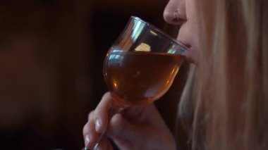 Güzellik Genç kadın beyaz şarap içme ve bir terasta gün batımı manzarasının tadını çıkarın. Güzel kız elinde bir kadeh şarap tutuyor ve pencereden dışarı bakıyor. Şarap tadımı.