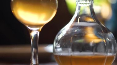 Wineglass with carafe full of the white wine on the table.