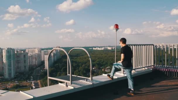 Bonito cara meditando na borda do telhado, sentindo-se confiante e livre — Vídeo de Stock