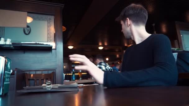 Heureux, jeune homme assis dans un café — Video