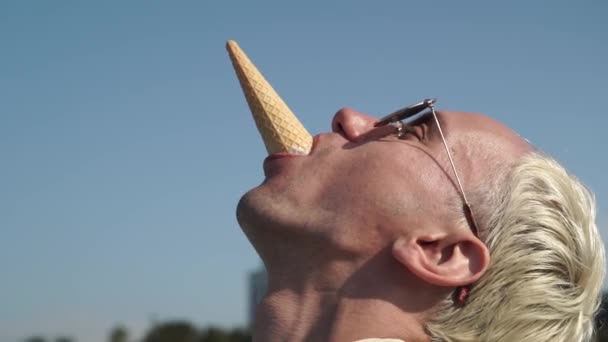 Extraño joven divertido chico eatc delicioso helado al aire libre — Vídeos de Stock