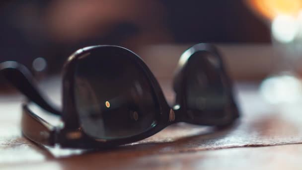 Close-up óculos de sol na mesa de madeira . — Vídeo de Stock