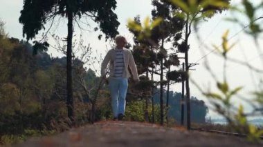 Ağaçların Altında Yürüyen Genç Yürüyüşçü. Seyahat Konsepti.