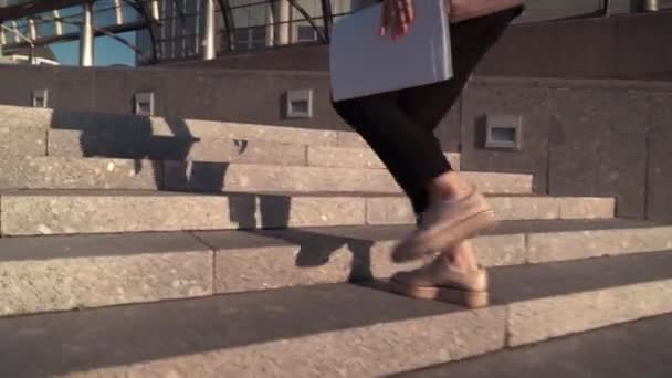 Jóvenes mujeres de negocios en chaqueta negra tarde y correr en la escalera con el documento de papel en las manos — Vídeo de stock