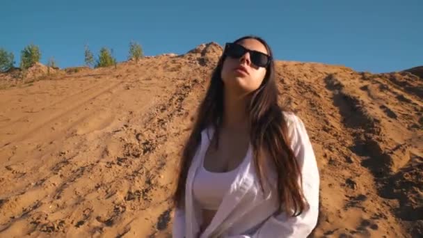 Young brunette girl in the desert hot on the sand — Stock Video