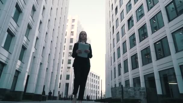 Young Business vrouwen of student in zwarte jas wandelen op straat met papieren document in de hand — Stockvideo