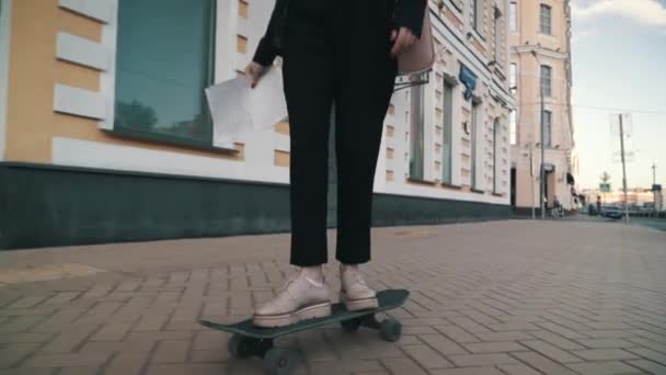 Meisje in een pak rijden op een skateboard. Benen op het skateboard, gaat naar succes — Stockvideo