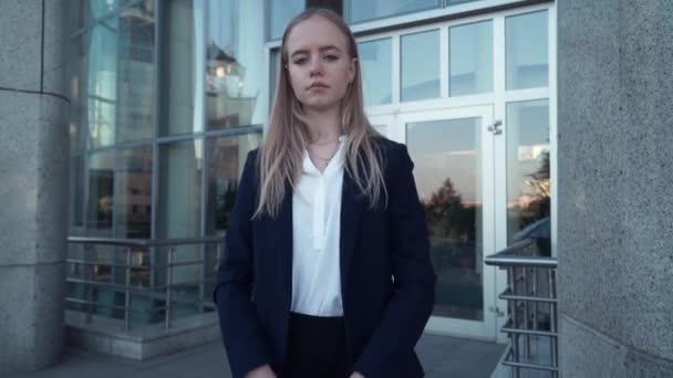 Unga företag kvinnor eller student i svart jacka titta på kameran och riva tomma pappersark till bitar och sprida dem — Stockvideo