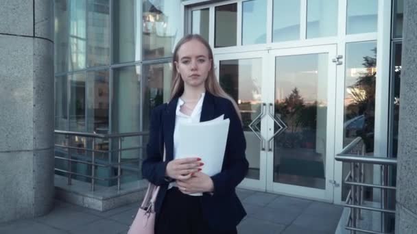 Retrato de joven mujer de negocios hermosa o estudiante de traje. Está parada en el centro de la ciudad. Concepto: nuevo negocio, comunicación, banquero, gerente — Vídeos de Stock