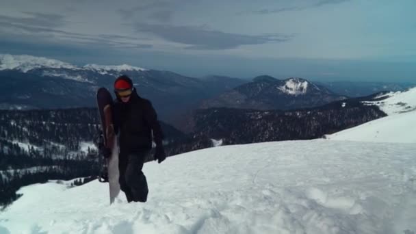 Sportsman jít s vybavení na snowboard na kopci sníh — Stock video