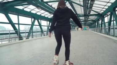 Paten sürme kız. Güzel bir tünel içinde sokakta şehir içi paten sürme genç esmer kadın