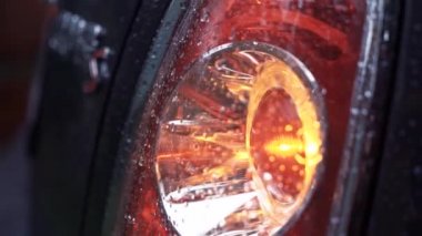 Modern araba yanıp söner Far. Siyah araba far yakın çekim, sarı ışık yağmurdan sonra yanıp sönen