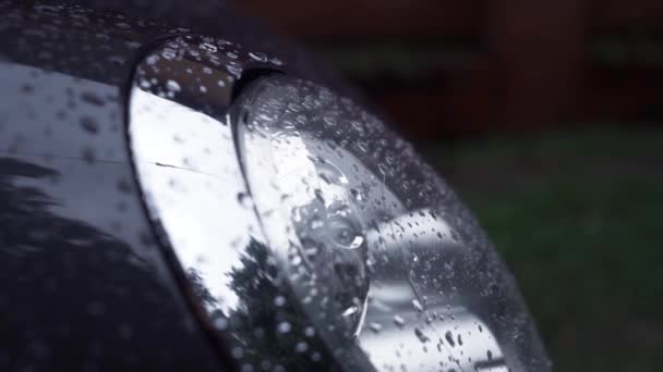 Primer plano de coche nuevo moderno con faros parpadeantes se deja en la calle vacía en frío gris nublado lloviendo el día de otoño — Vídeos de Stock