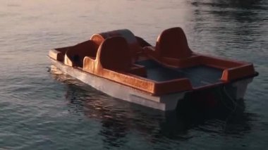 Katamaran denizde suyun üzerinde duruyor. Deniz kıyısında gün doğumu. Kumlu plaj, yaz sabahı deniz dalgaları tarafından yıkandı.